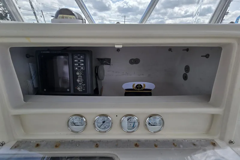 Slide: The Image of 1998 Fountain 25 Center Console dashboard with gauges and captain's hat. - 18