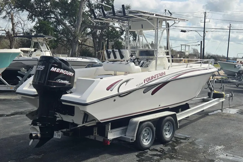 Slide: The Image of 1998 Fountain 25 Center Console boat on trailer with Mercury engine, parked outdoors. - 3