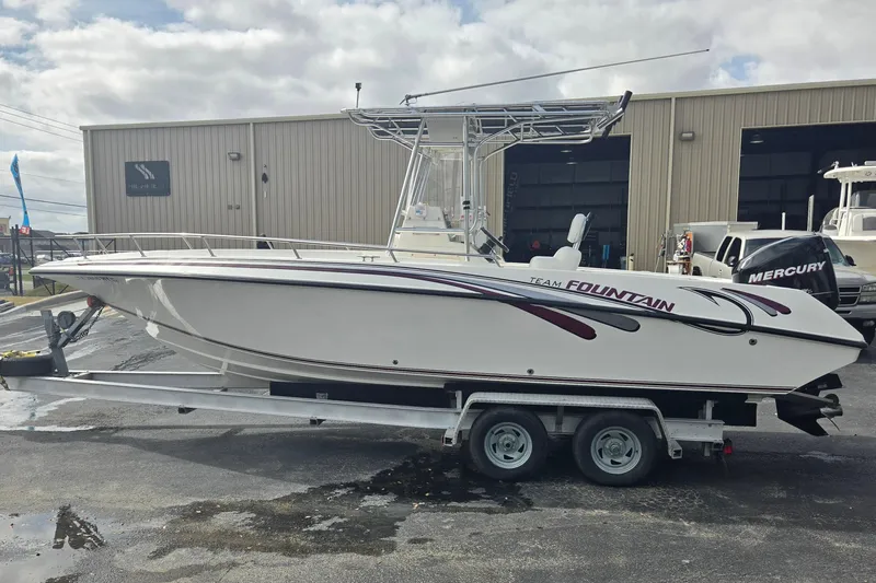 Slide: The Image of 1998 Fountain 25 Center Console boat on trailer, parked outside a warehouse. - 6