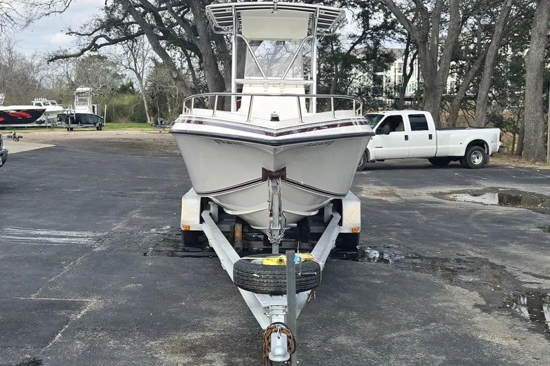 Slide: The Image of 1998 Fountain 25 Center Console boat on trailer, parked near white truck. - 8