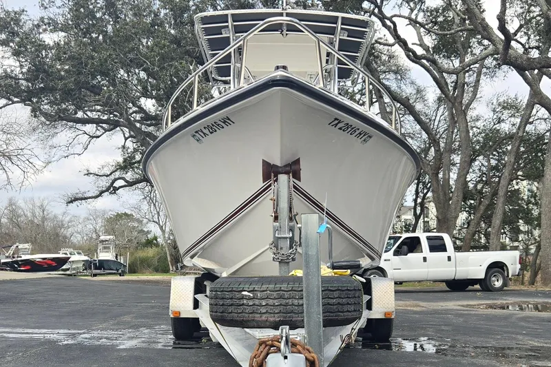 Slide: The Image of 1998 Fountain 25 Center Console boat on trailer, parked near trees and a white truck. - 9