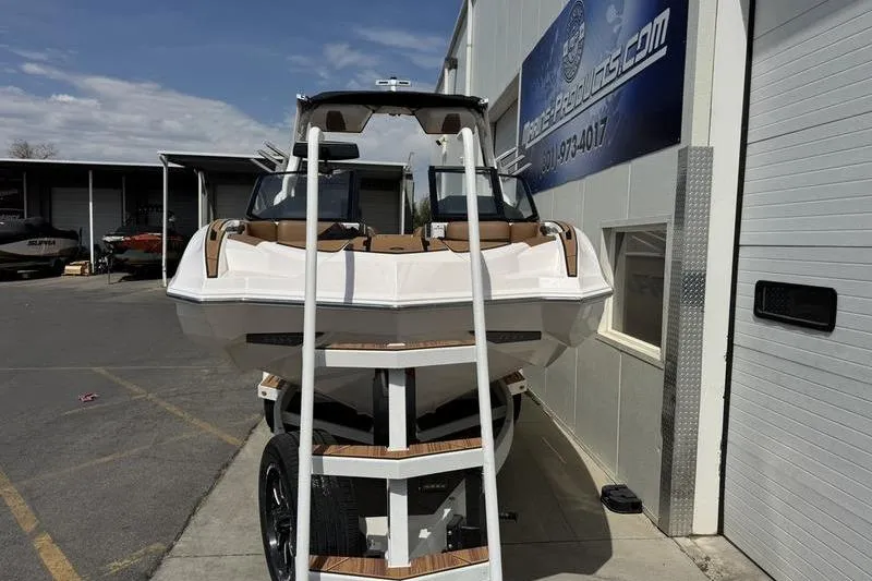 Slide: The Image of 2024 Supra SE 575 boat on trailer outside dealership. - 4