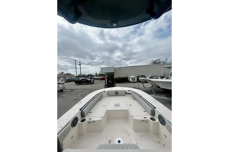 Slide: The Image of 2026 Carolina Skiff 22 Ultra Elite boat interior with seating and storage, parked outdoors. - 10