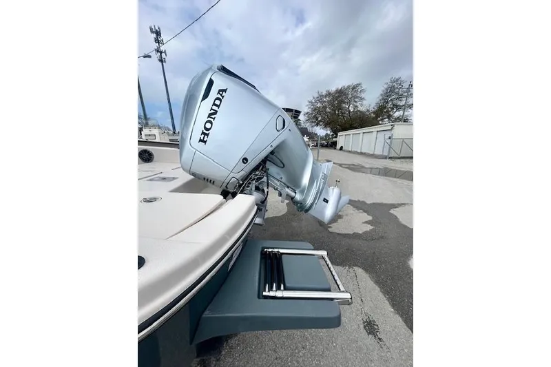 Slide: The Image of 2026 Carolina Skiff 22 Ultra Elite with Honda outboard motor, docked on a cloudy day. - 12