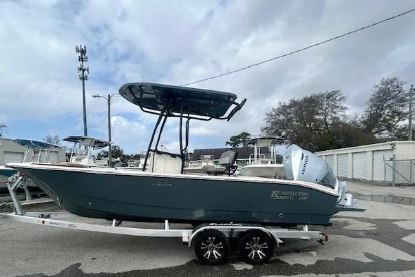 Slide: The Image of 2026 Carolina Skiff 22 Ultra Elite boat on trailer, parked outdoors. - 2