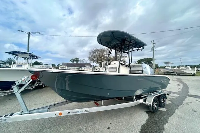 Slide: The Image of 2026 Carolina Skiff 22 Ultra Elite boat on trailer, parked outdoors under cloudy sky. - 3