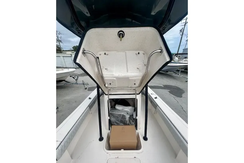 Slide: The Image of 2026 Carolina Skiff 22 Ultra Elite boat storage compartment open, revealing interior space. - 6