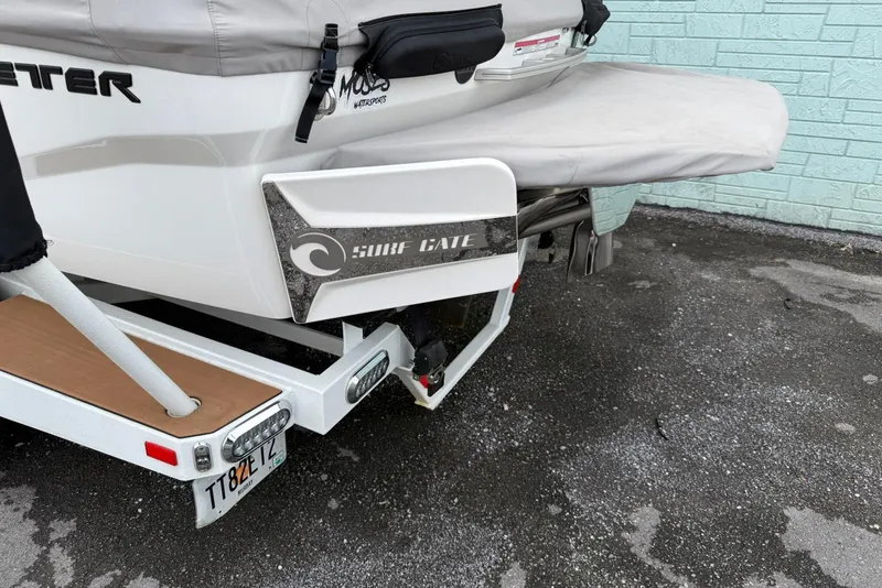 Slide: The Image of 2020 Malibu Wakesetter 21 VLX boat with Surf Gate feature, parked on a trailer. - 16