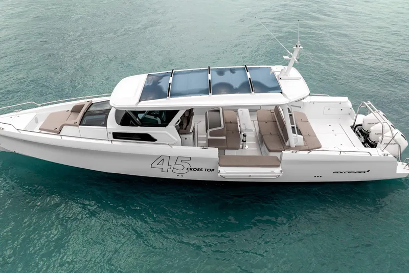 Slide: The Image of 2025 Axopar 45 Cross Top boat on clear blue water, showcasing sleek design and spacious deck. - 10