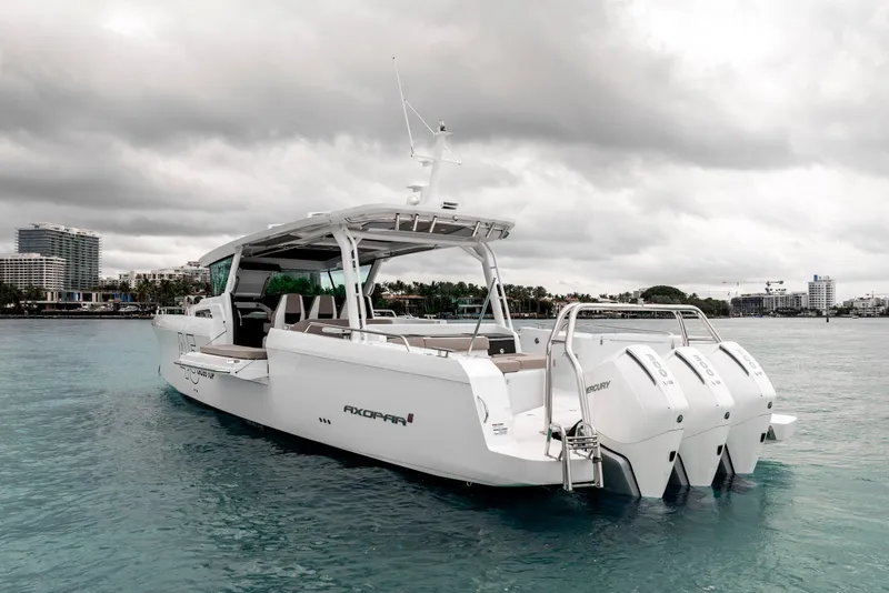 Slide: The Image of 2025 Axopar 45 Cross Top boat on calm water, overcast sky. - 12