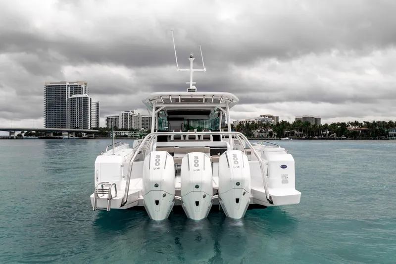 Slide: The Image of 2025 Axopar 45 Cross Top boat with triple engines on a calm water backdrop. - 13