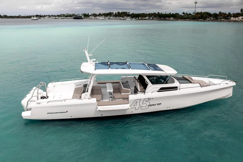 Slide: The Image of 2025 Axopar 45 Cross Top boat on turquoise water, showcasing sleek design and modern features. - 16