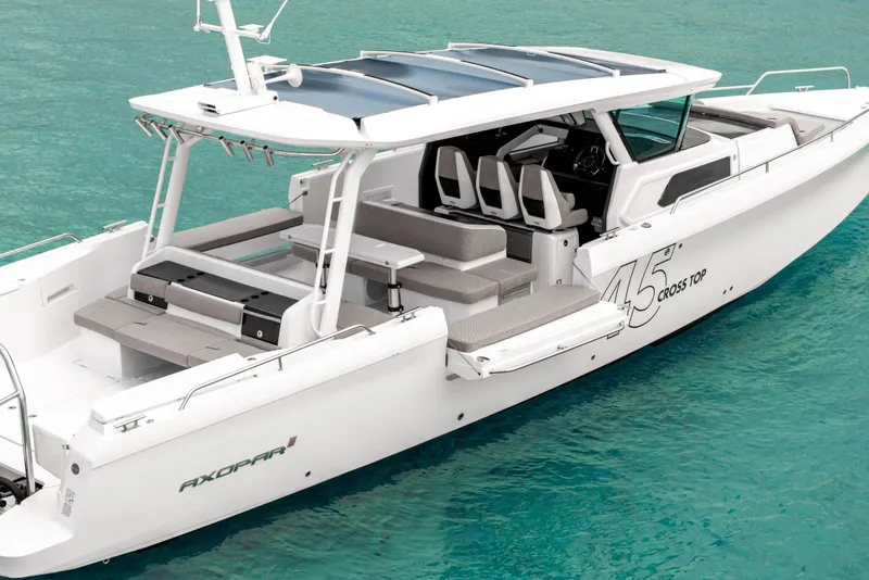 Slide: The Image of 2025 Axopar 45 Cross Top boat on turquoise water, featuring sleek design and spacious seating. - 21