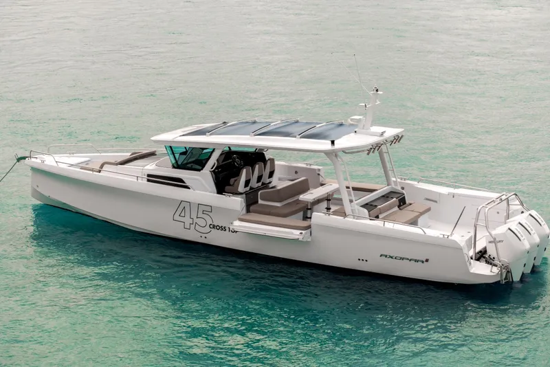 Slide: The Image of 2025 Axopar 45 Cross Top boat on clear turquoise water. - 23