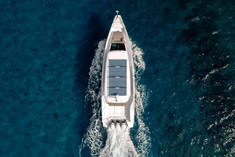 Slide: The Image of Aerial view of 2025 Axopar 45 Cross Top boat cruising on clear blue water. - 27