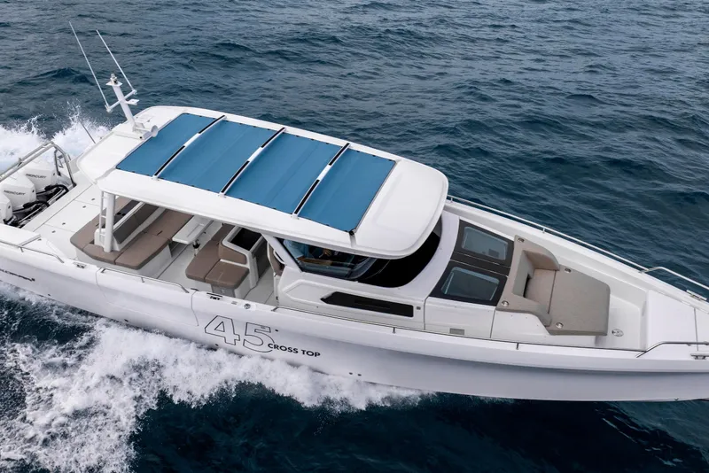 Slide: The Image of 2025 Axopar 45 Cross Top boat cruising on open water, showcasing sleek design. - 32