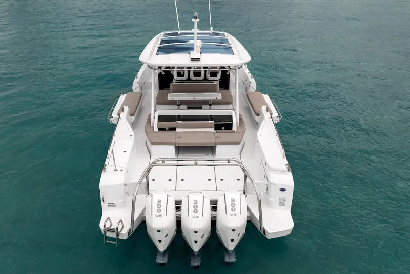 Slide: The Image of 2025 Axopar 45 Cross Top boat with triple engines on turquoise water. - 4