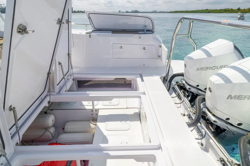 Slide: The Image of 2025 Axopar 45 Cross Top boat with open storage compartments and dual Mercury engines. - 44