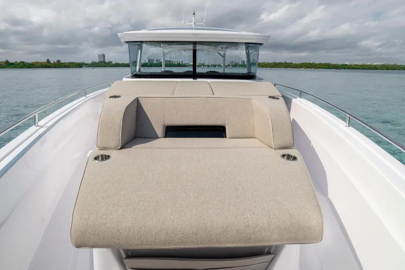 Slide: The Image of 2025 Axopar 45 Cross Top boat with spacious deck and seating, on calm waters. - 49