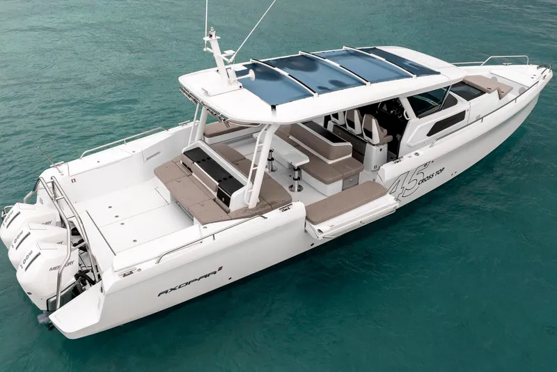 Slide: The Image of 2025 Axopar 45 Cross Top boat on clear blue water, showcasing sleek design and spacious deck. - 5