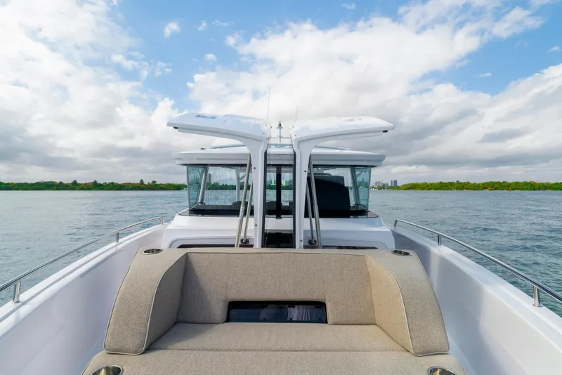 Slide: The Image of 2025 Axopar 45 Cross Top boat on water with open canopy and seating. - 53