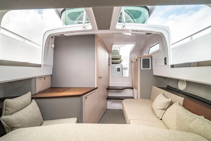 Slide: The Image of Interior of 2025 Axopar 45 Cross Top boat, featuring modern seating and wooden accents. - 58
