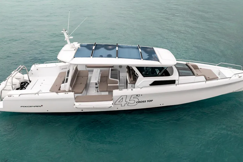 Slide: The Image of 2025 Axopar 45 Cross Top boat on clear blue water, showcasing sleek design and spacious deck. - 6