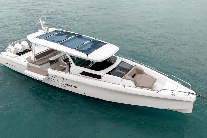 Slide: The Image of 2025 Axopar 45 Cross Top boat on clear blue water, showcasing sleek design and spacious deck. - 7
