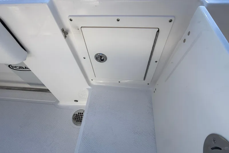 Slide: The Image of 2024 Robalo R230 Center Console boat storage compartment and drain detail. - 13