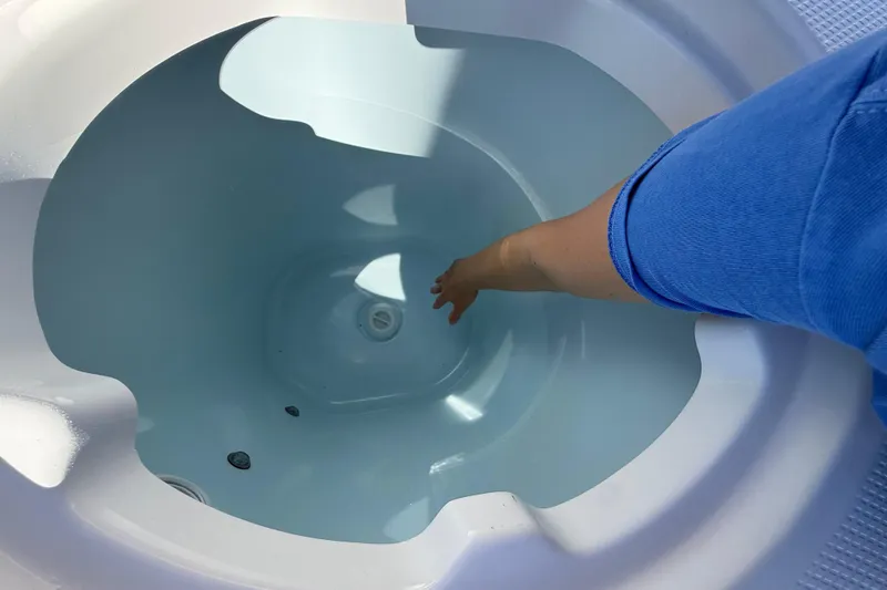 Slide: The Image of Person reaching into Robalo R230 Center Console livewell, 2024 model. - 18