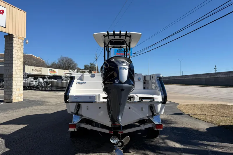 Slide: The Image of 2024 Robalo R230 Center Console boat with powerful outboard motor, parked outdoors. - 2