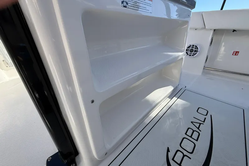 Slide: The Image of 2024 Robalo R230 Center Console boat interior with storage compartments and logo. - 27