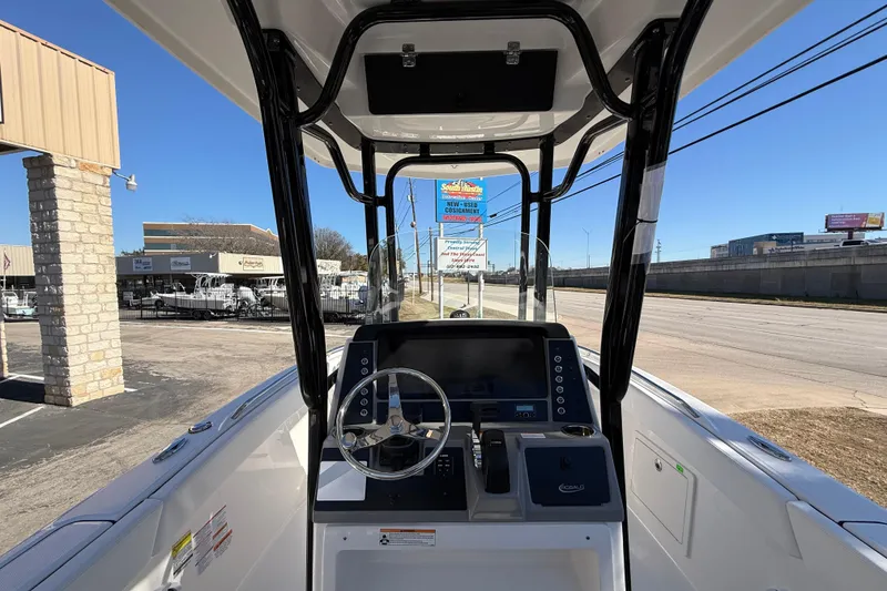 Slide: The Image of 2024 Robalo R230 Center Console boat interior with steering wheel and dashboard view. - 28