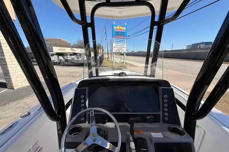 Slide: The Image of 2024 Robalo R230 Center Console boat dashboard with steering wheel and controls. - 29