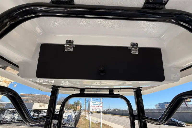 Slide: The Image of 2024 Robalo R230 Center Console boat's overhead storage compartment with black panel and latches. - 40