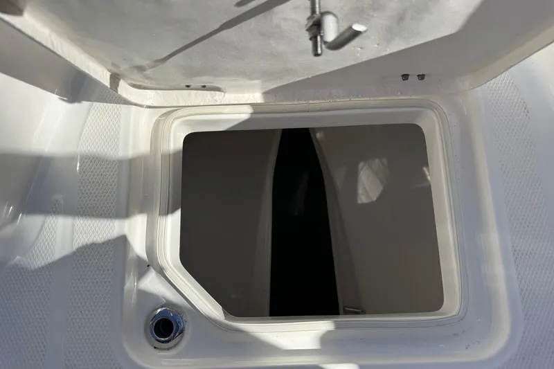 Slide: The Image of 2024 Robalo R230 Center Console storage compartment with open hatch. - 46