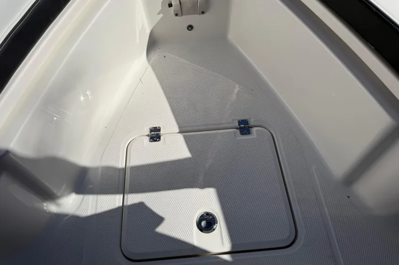 Slide: The Image of 2024 Robalo R230 Center Console boat storage compartment with textured flooring. - 47