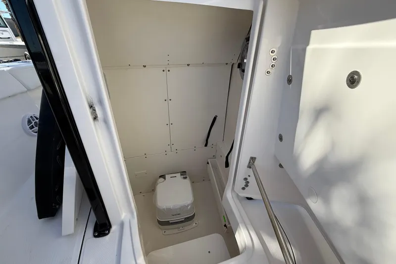 Slide: The Image of 2024 Robalo R230 Center Console interior with compact marine toilet. - 53