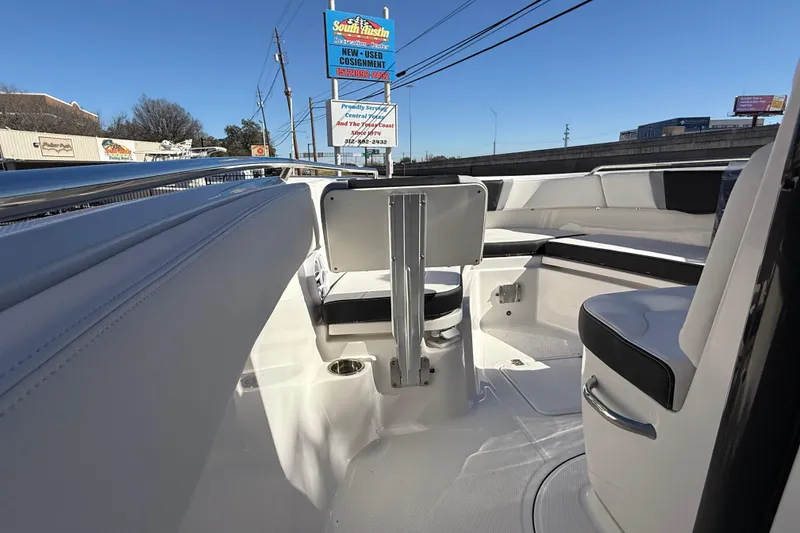 Slide: The Image of 2024 Robalo R230 Center Console boat interior with seating and railings, under clear blue sky. - 58