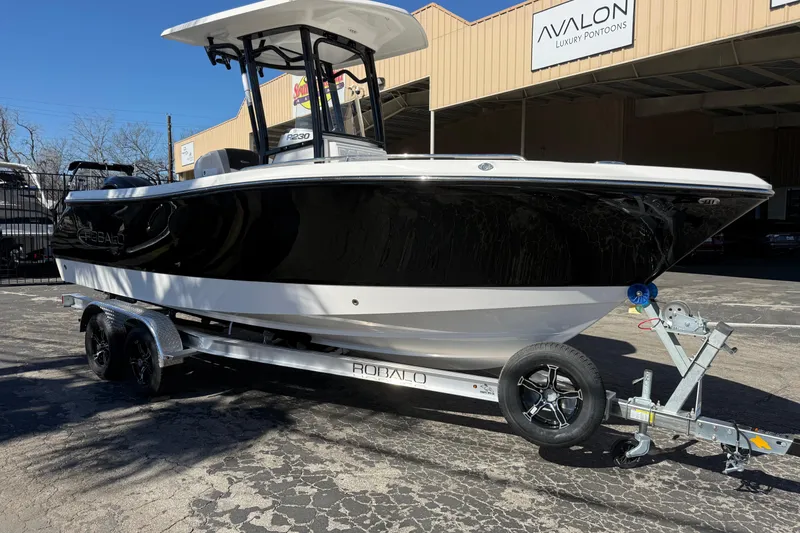 Slide: The Image of 2024 Robalo R230 Center Console boat on trailer outside Avalon Luxury Pontoons. - 6
