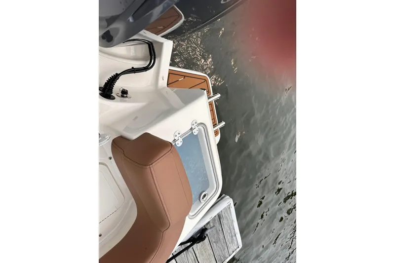 Slide: The Image of 2024 Pioneer 222 Islander boat interior with tan seating and water view. - 14