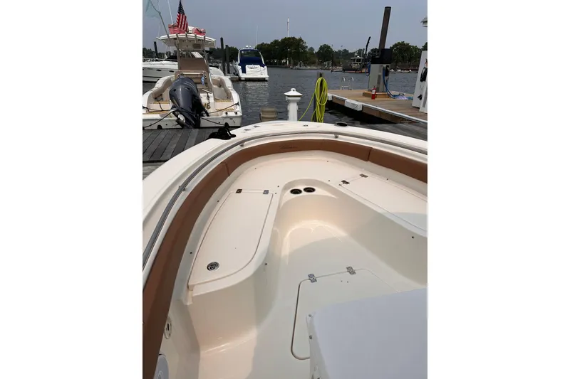 Slide: The Image of 2024 Pioneer 222 Islander boat docked, showcasing spacious seating and sleek design. - 2