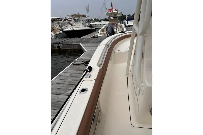 Slide: The Image of 2024 Pioneer 222 Islander boat docked at marina, showcasing sleek design and spacious deck. - 3