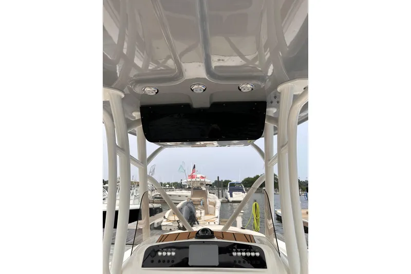 Slide: The Image of 2024 Pioneer 222 Islander boat interior with modern dashboard and overhead lighting. - 6