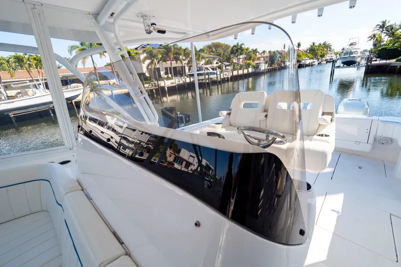 Slide: The Image of 2019 Intrepid 407 Cuddy boat interior with sleek design and waterfront view. - 100