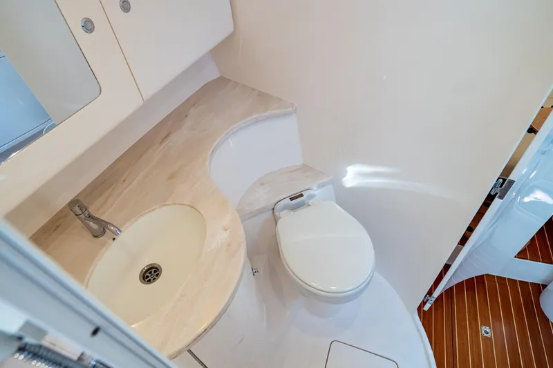 Slide: The Image of 2019 Intrepid 407 Cuddy bathroom with sink and toilet, featuring wooden flooring. - 105