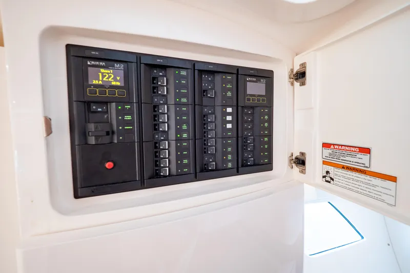 Slide: The Image of Electrical panel inside 2019 Intrepid 407 Cuddy boat, showing voltage and circuit breakers. - 118