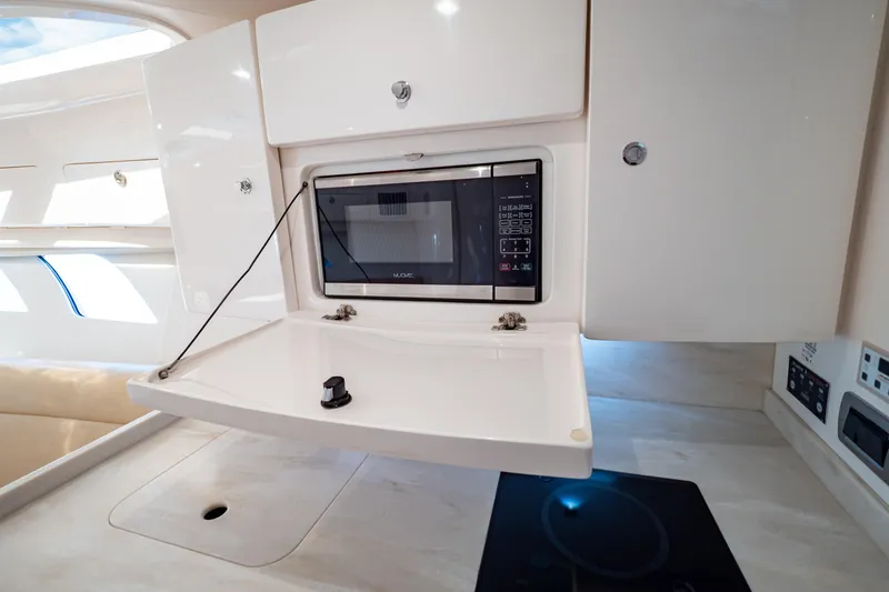 Slide: The Image of 2019 Intrepid 407 Cuddy interior with microwave and sleek cabinetry. - 120