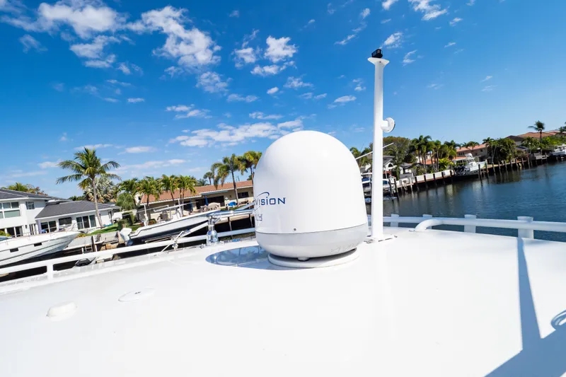 Slide: The Image of 2019 Intrepid 407 Cuddy boat with satellite dome, docked near waterfront homes. - 122