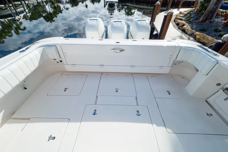 Slide: The Image of 2019 Intrepid 407 Cuddy boat deck with storage compartments and seating. - 27